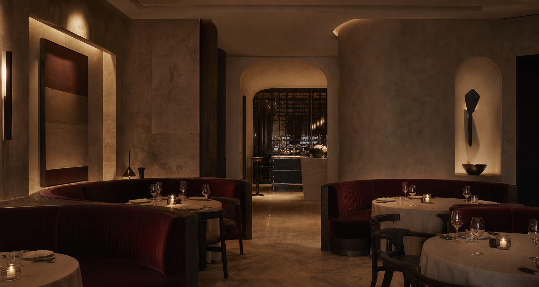 Elegant fine dining interior with warm stone walls, candlelit tables, and deep burgundy banquettes